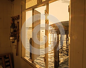 view through a wooden window during sunset at a Thai village in the ocean at the fishing town