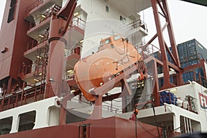 Close view at a container ship with rescue boat