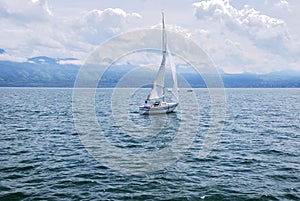 View of the yacht against the backdrop of the mountains on Lake Geneva