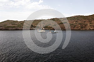 A view of a yacht and a fishing boat in the sea, in the island of Patmos, Greece in summer