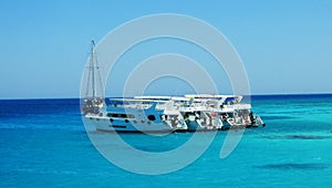 Yacht parking with tourists near White Island in Red sea.