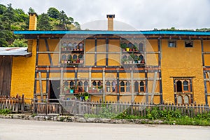 View of a yellow house in a village in Bhutan.