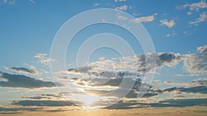 View of yellow sun setting in the orange sky with dark clouds. Timelapse.