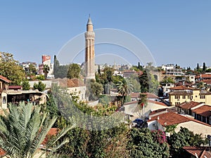 View of the Yivliminare Mosque minaret and cityscape before a blue skyline