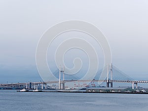 View of Yokohama Bay Bridge and Yokohama sea port with warehouses at dusk