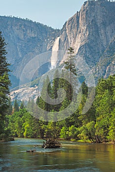 View of Yosemite Falls from the bridge above Merced River in Yosemite Valley National Park, California, USA.