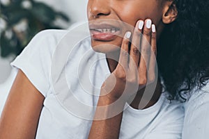 View of young african american woman suffering from jaw pain