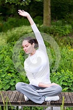 Young attractive woman practising yoga in a park