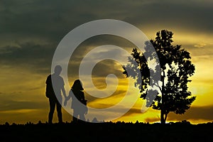 View of young couple walking along the shore during sunset