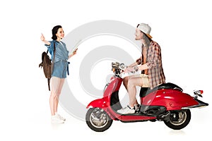 View of young man on red scooter and girl outstretched hand with thumb up isolated on white