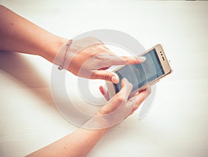 View of a young woman`s hands holding a smartphone for online communicating, paying, shopping.