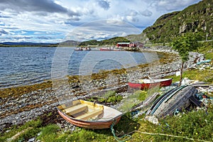 The view at Ytrebukta bay with small boats and fisher huts along the coastline of Porsangerfjorden in Norwegian Finnmark, close to