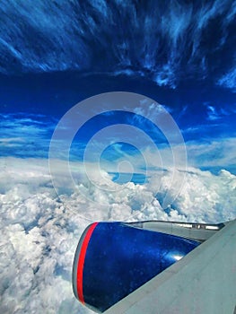 Viewed from airplane windows with a wing, blue sky and white cloud