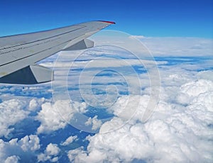 Viewed from airplane windows with a wing, blue sky and white cloud