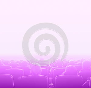 Viewers at movie theater, pink toning white copy space