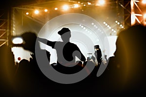 Viewers under the stage. The man with raised hands during summer festival rock concert.