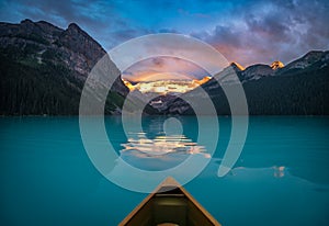 Viewing snowy mountain in rising sun from a canoe