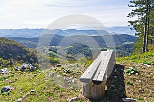 Viewpoint with a bench at mount Bobija, beautiful view of surrounding peaks, hills, meadows and colorful forests