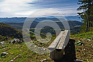Viewpoint with a bench at mount Bobija, beautiful view of surrounding peaks, hills, meadows and colorful forests