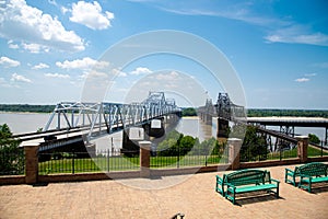 Viewpoint with benches, metal fence overlooking landmark Twin Vicksburg Bridge, cantilever and railroad transportation carrying