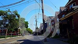 Viewpoint of City Street With Oncoming Traffic.  Urban Road Along Residential Houses During Summer