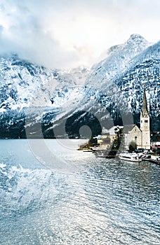 Viewpoint of Hallstatt old town city snow mountains and lake with reflection in the water in Winter season landscape portrait