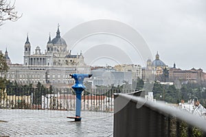 Viewpoint with metal railing with coin operated telescope overlooking the Almudena cathedral in Madrid in Spain