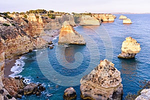 Viewpoint of the natural arches, orange cliffs and turquoise waters, at sunset. Concept of tourism and travel. Algarve, Portugal