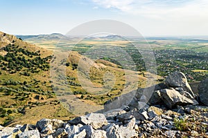 Viewpoint over a flat valley with rural villages surrounded by farmlands and arid hills