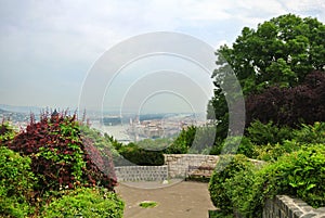 A viewpoint at the park over the hill at Budapest, a view to Danube river and a building of Parliament and a bench
