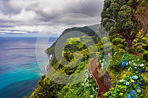 Viewpoint Ponta do Sossego, Sao Miguel Island, Azores, Portugal. View of flowers on a mountain and the ocean in Miradouro da Ponta photo