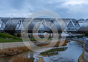 Views of the Arganzuela Bridge on a cloudy day, pedestrian bridge crossing the Manzanares River in the Madrid RÃÂ­o Park, formed by photo