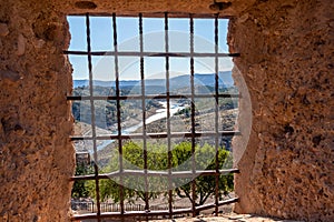 Views through a castle window with wrought iron grating Castle grill