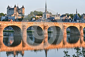 Views of the city of Saumur from the riverbank at dusk, with the castle in the background. Loire Valley, France