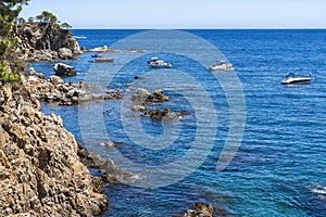 Views of the coast in `Ses Negres` with boats in Calella de Palafrugell. photo