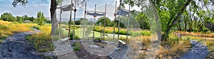 Views of Jordan River Trail with surrounding trees, Russian Olive, cottonwood and silt filled muddy water along the Wasatch Front