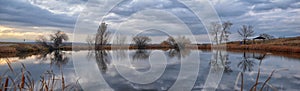 Views of Joshâ€™s Pond walking path, Reflecting Sunset in Broomfield Colorado surrounded by Cattails, plains and Rocky mountain la