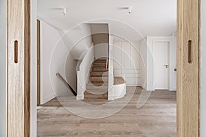 views of a large hall of a recently renovated modern house with a white oak wooden bench with drawers, a white wardrobe next to