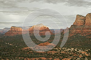 Views of red rock buttes and formations within coconino national forest in Sedona Arizona USA against white cloud background.