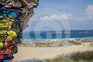 Views of the sea from the beach, the sea is azure blue, as is the sky. Next to it is the wall of some old building demolished.