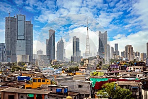 Views of slums on the shores of mumbai, India against the backdrop of skyscrapers under construction