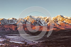 The views of the snowy peaks and the river valley at dawn.