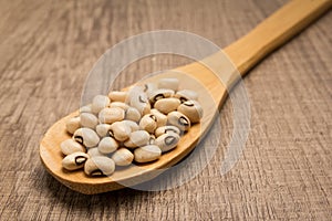 Black Eyed Pea legume. Spoon and grains over wooden table.