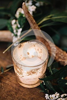 A vignette of a candle in a gold mercury glass holder from a table scape designed for a boho style event with rustic touches and