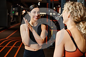 vigorous cheerful female coach helping her