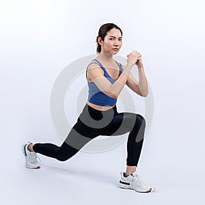 Vigorous energetic woman doing exercise with squat on isolated background.