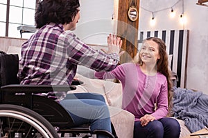 Vigorous immobile woman and girl exchanging high five