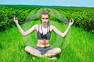 Viking aggressive makeup girl cosplay in a green wheat field. Kneeling, praying to the ancient gods. Paganism, feminism,