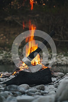 Viking ax. An ax driven into a piece of wood. Ax in the water. An ax by the fire