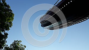 Viking boat in a fairground attraction, seen from below, with blue sky day background